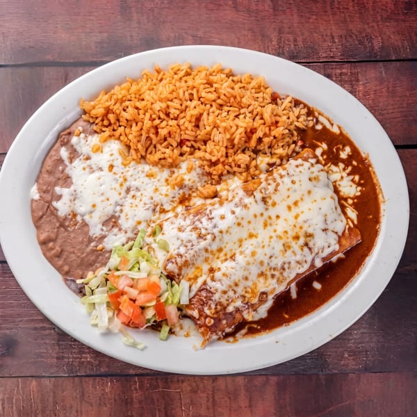 A white plate with a cheesy enchilada, refried beans, Mexican rice, and a side salad.