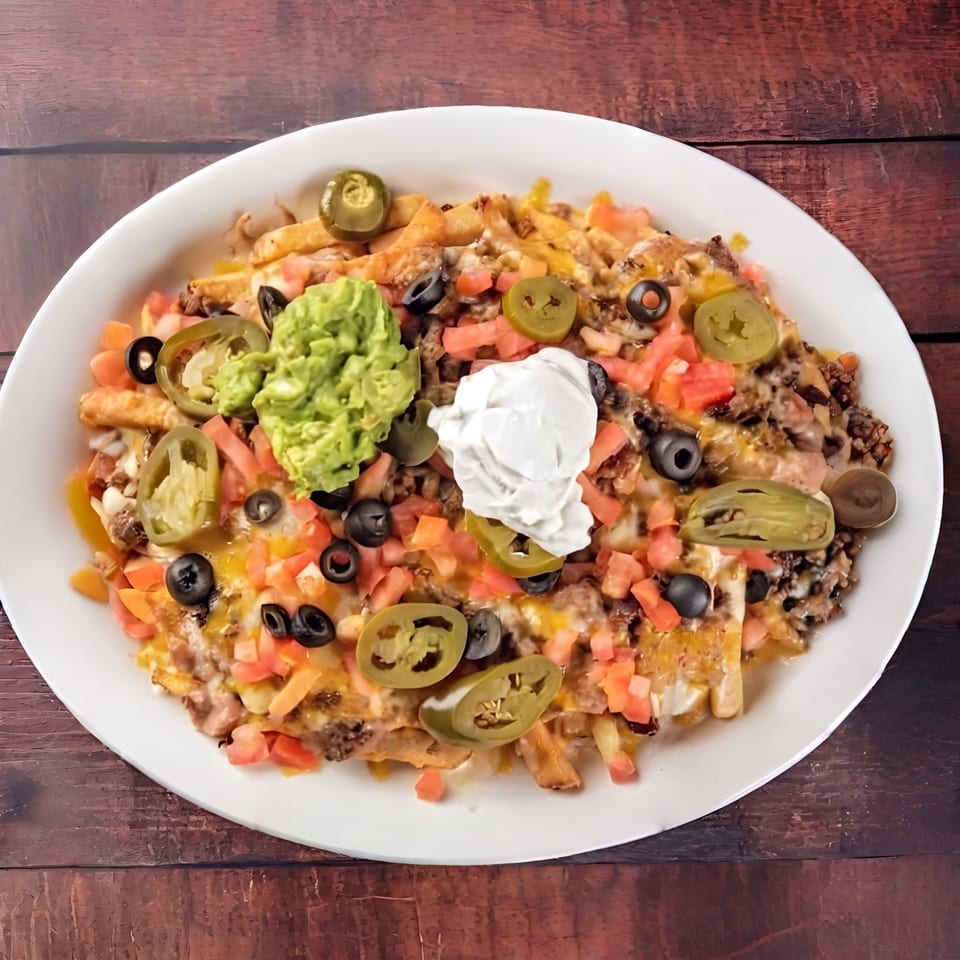Loaded fries topped with melted cheese, ground beef, guacamole, sour cream, jalapeños, olives, and tomatoes.